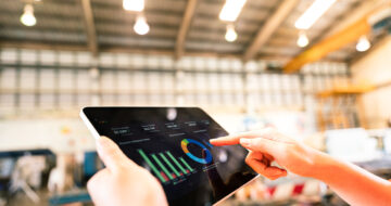 A worker is using tablet to review storage report - Business management and technology concept photo.